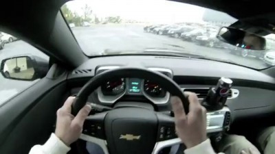 Загримированный Джеф Гордон тестирует авомобиль в автосалоне .