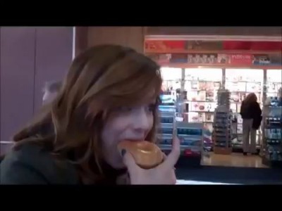 Девушка ест пончик, чтобы не испачкаться кремом