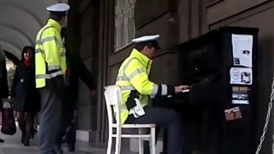 Pražský strážník hraje na pouliční piáno