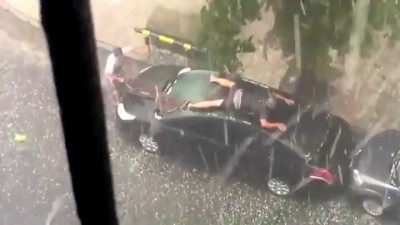 Мужик защищает машину от града